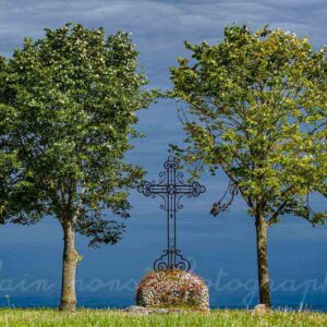 photographie de deux arbres et une croix en couleur, un joli ciel, à Charroux, Allier, en Auvergne.