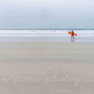 Photographie Le surfeur solitaire et sa planche orange à la plage des blancs sablons, le Conquet, Finistère, Bretagne.