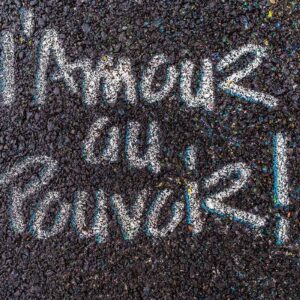 photographie l'Amour au Pouvoir, un beau slogan peint sur le goudron d'une rue à Clermont-Ferrand.