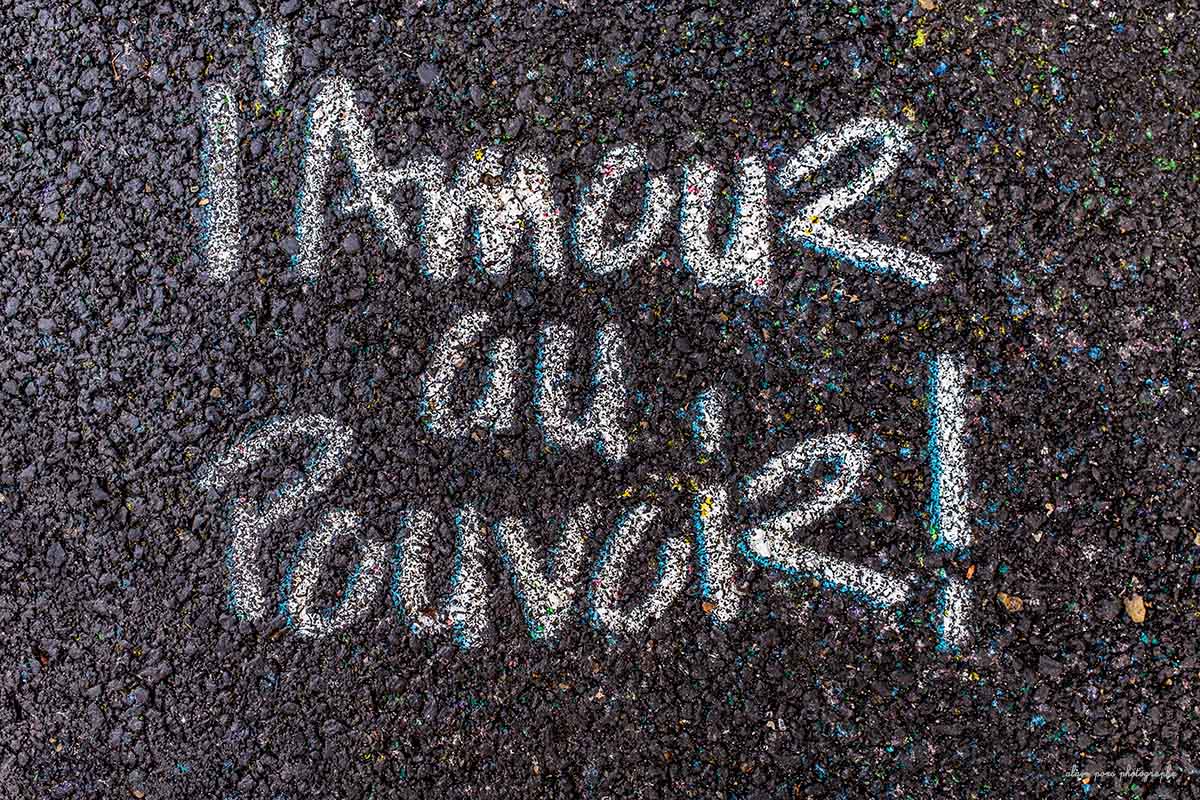 photographie l'Amour au Pouvoir, un beau slogan peint sur le goudron d'une rue à Clermont-Ferrand.
