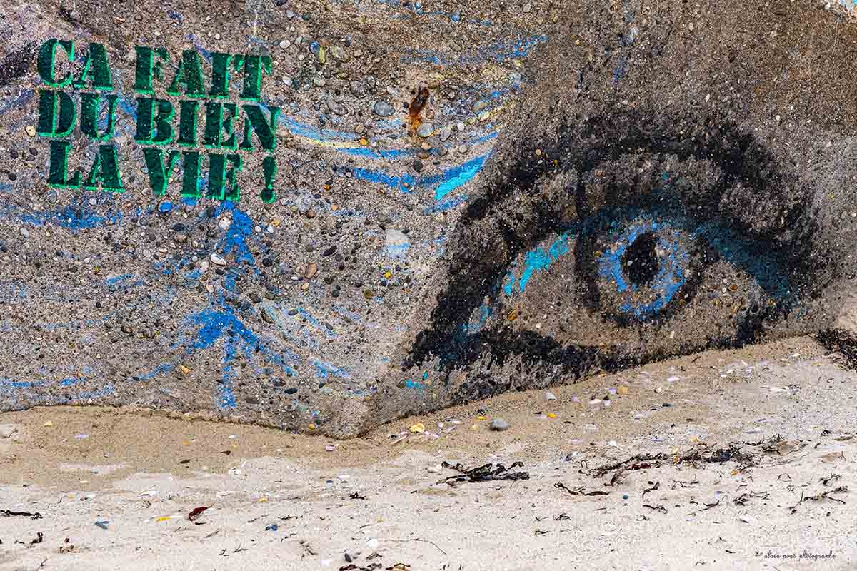 Photographie d'une peinture murale sur un blockhaus avec ce slogan, "ça fait du bien la vie".