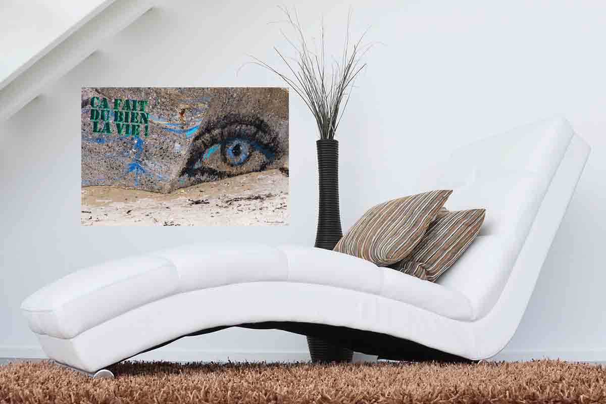 Photographie du slogan graffiti "Ça fait du bien la vie" en décoration dans un salon.