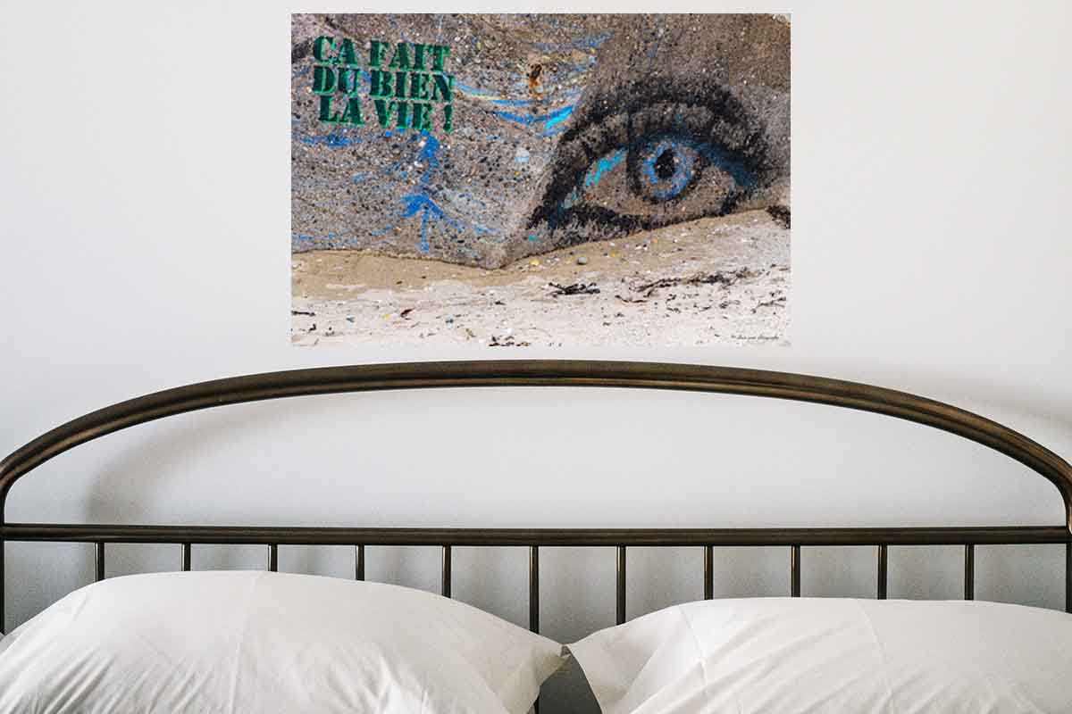 photographie du graffiti slogan "Ça fait du bien la vie" en décoration dans une chambre.