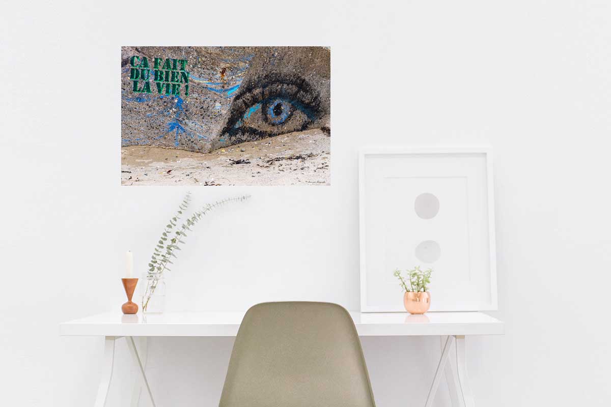 Photographie du slogan graffiti peint sur un blockhaus "Ça fait du bien la vie" ici en décoration dans un bureau.