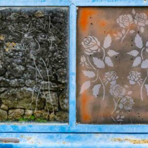 Photographie de deux gravures : une femme stylisée et un bouquet de roses, sur 2 vitres côte à côte,