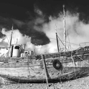 La photographie de l'épave du bateau de pêche artisanale Notre Dame des Neiges à Camaret-sur-Mer, en noir et blanc contrasté.