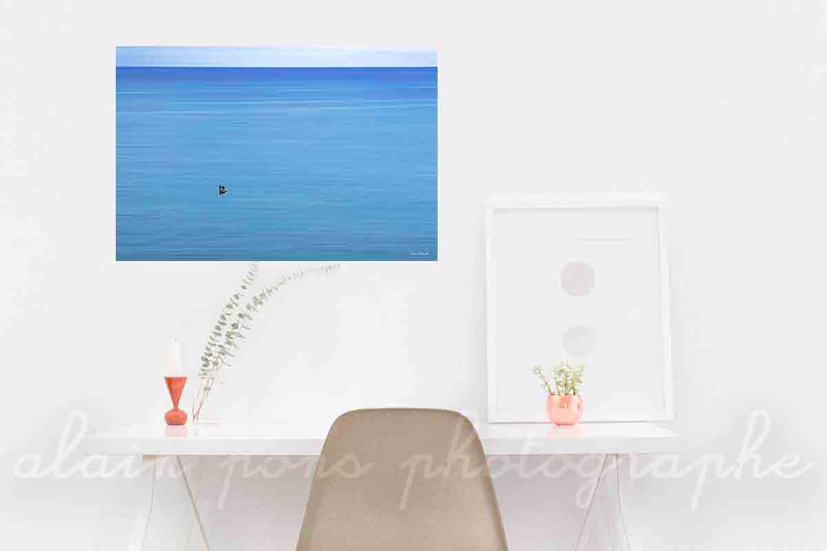 photographie de deux pêcheurs dans une barque sur une mer bleue. En affichage décoration dans un bureau.