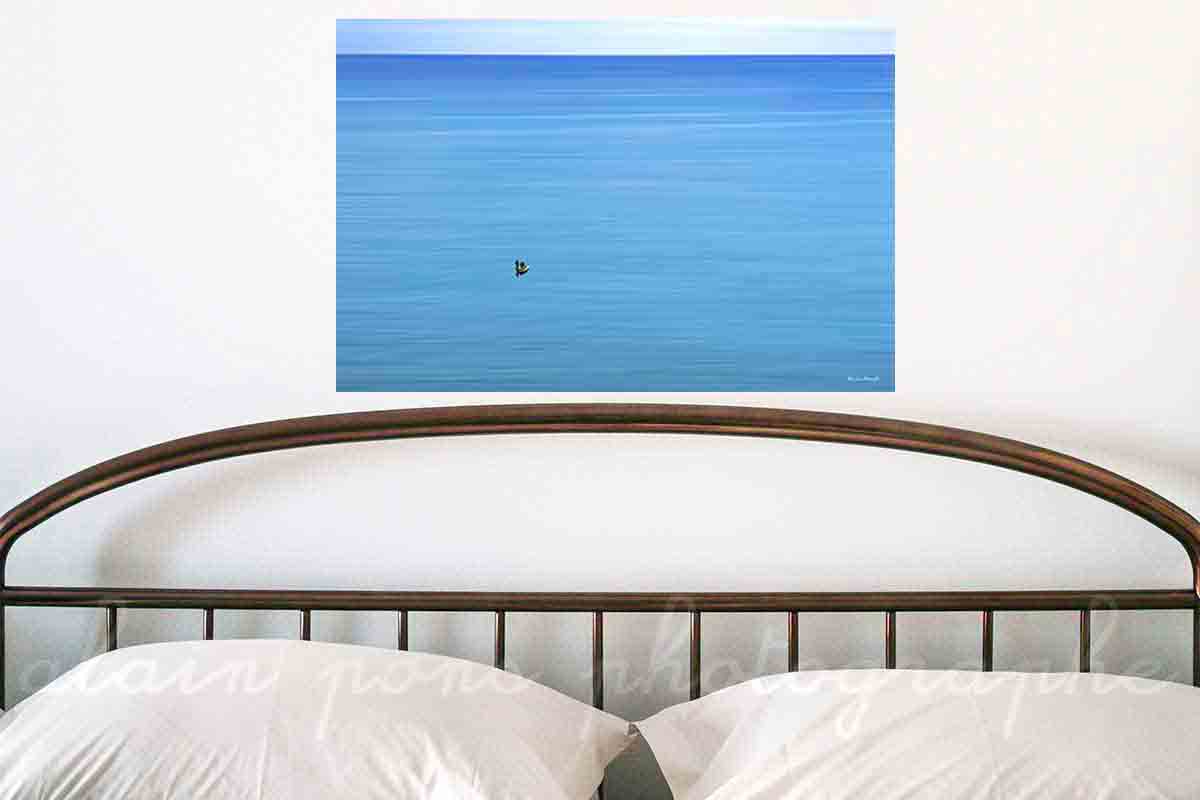 photographie de deux pêcheurs dans une barque sur une mer bleue. En affichage décoration dans une chambre.