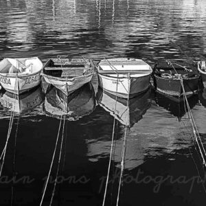 Photographie de 6 canots, aussi nommés annexes, dans le port de Concarneau, photographie en noir et blanc.