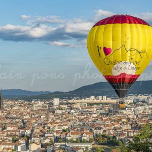 photographie de la montgolfière aux couleurs de la Chaîne des Puys faille de Limagne en survol au dessus de Clermont-Ferrand