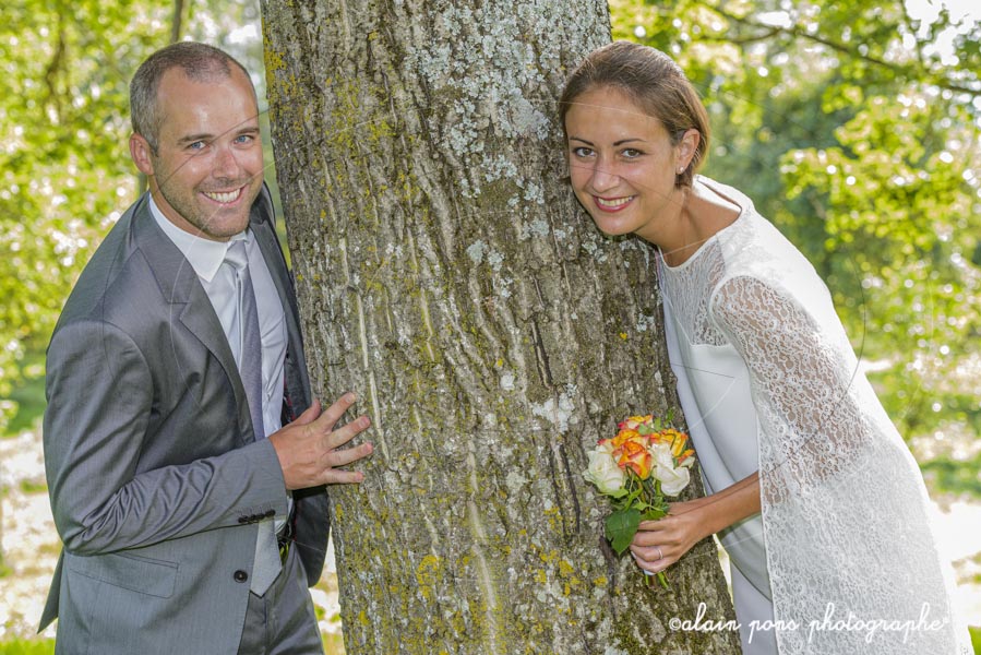 photographie d’un couple de mariés, autour d’un gros arbre, pleins sourires photographie d'un couple de mariés, autour d'un gros arbre, pleins sourires