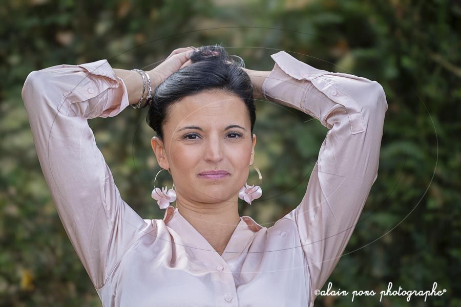 photographie d’un modèle féminin avec une chemise rose photographie d'un modèle féminin avec une chemise rose et des boucles d'oreilles avec des fleurs
