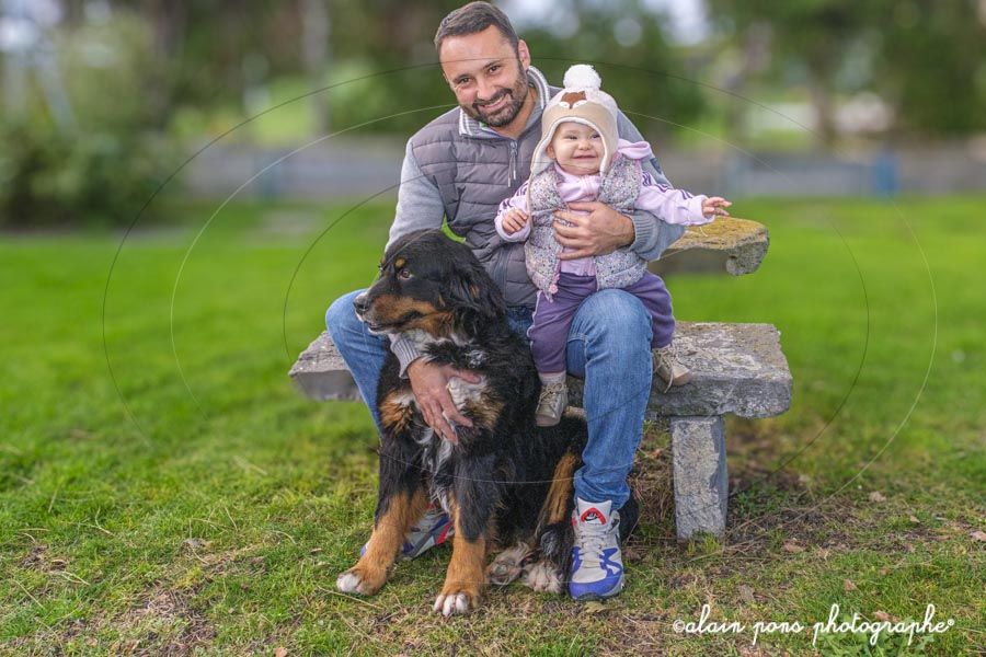 photographie d’un papa avec sa petite fille assis sur un banc en pierre et leur chien photographie d'un papa avec sa petite fille assis sur un banc en pierre et leur chien