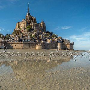 photographie du mont-saint-michel avec 2 voiliers dans l'estran à marée basse.