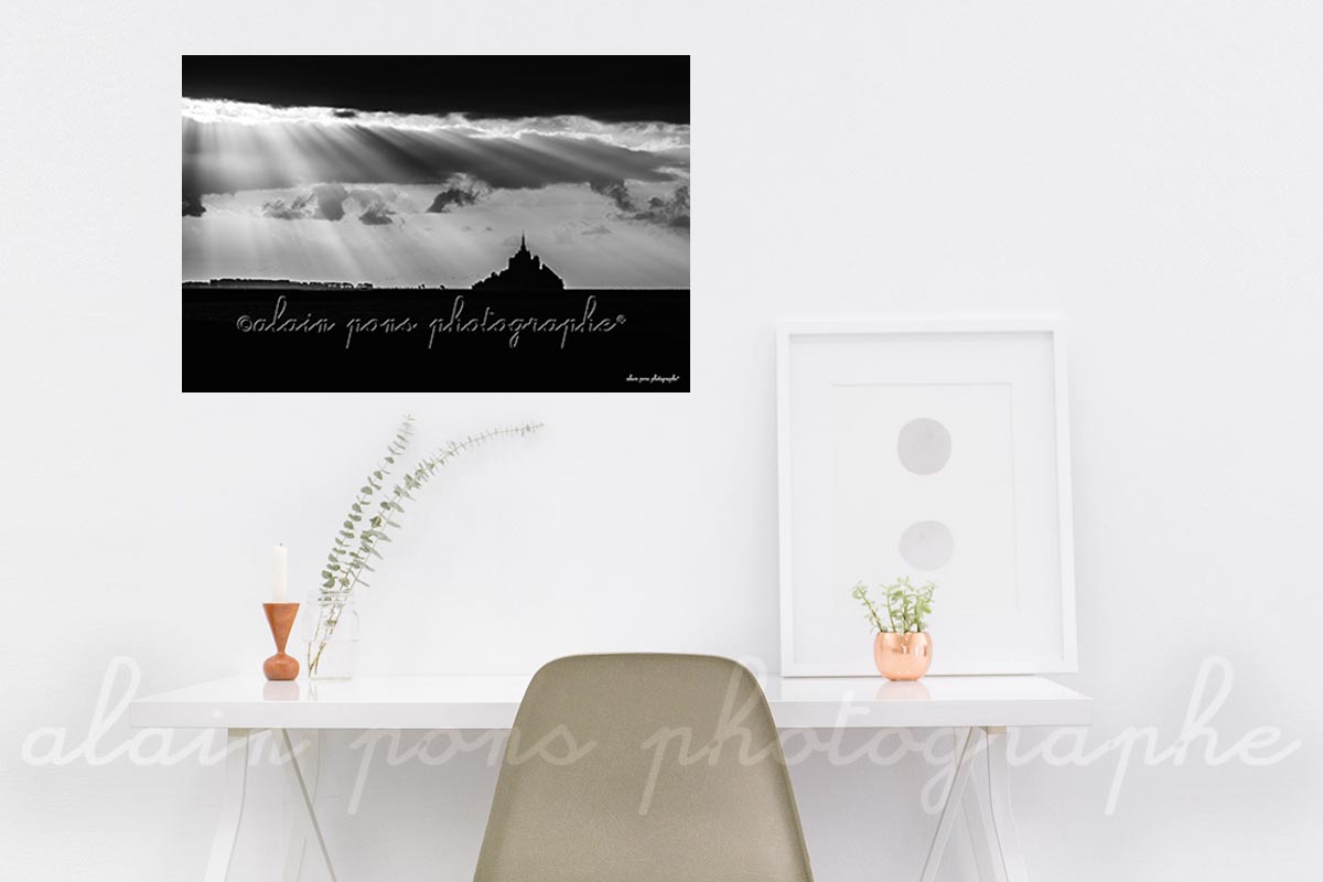 Photographie du Mont-Saint-Michel sous des rayons lumineux, en noir et blanc. Ici en décoration dans un bureau.