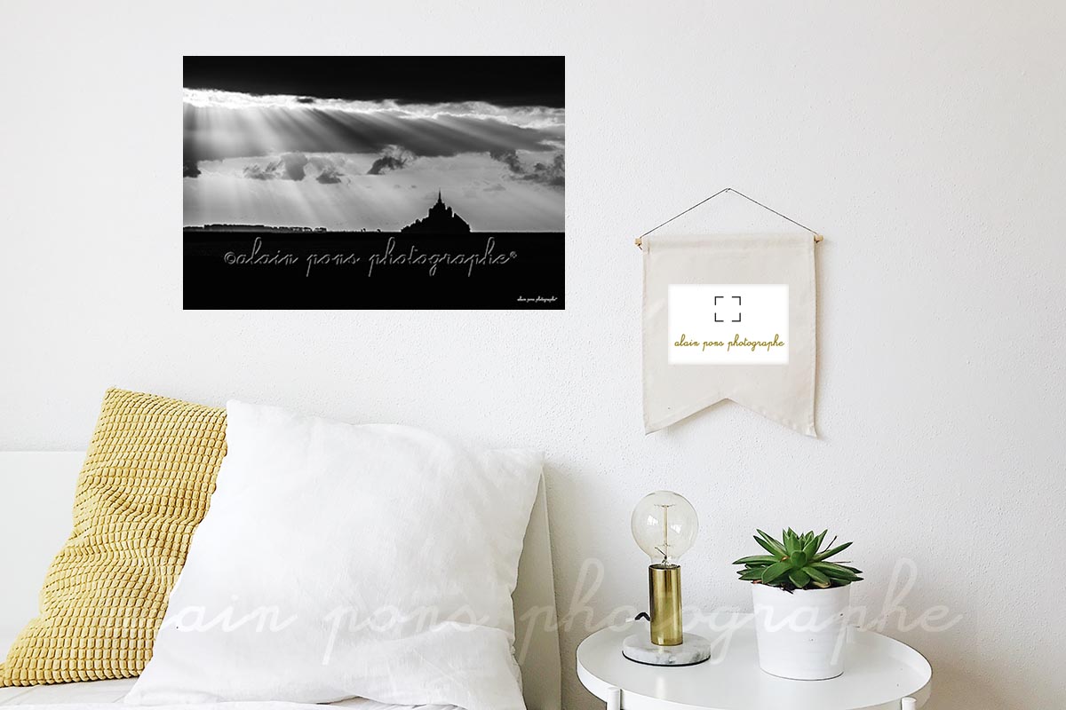 Photographie du Mont-Saint-Michel sous des rayons lumineux, en noir et blanc. Ici en décoration dans une chambre.