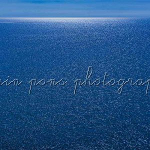photographie Le grand bleu de la belle Méditerranée. Une mer entièrement bleue avec au fond de la mer à l'horizon un rayon de lumière blanche.