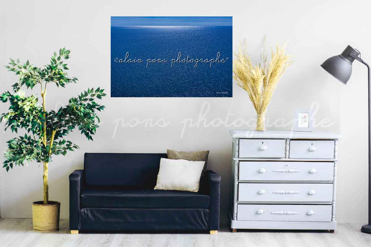 photographie Le grand bleu de la belle Méditerranée. Une mer entièrement bleue avec au fond de la mer à l'horizon un rayon de lumière blanche. Ici en décoration dans un salon.